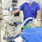 patient uses breathing device nurse monitors